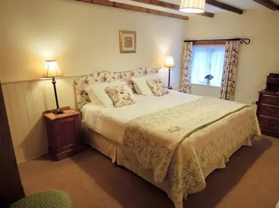a bedroom with a large bed and a window at The Cider Barn in St Austell
