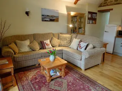 a living room with a couch and a table at The Cider Barn in St Austell