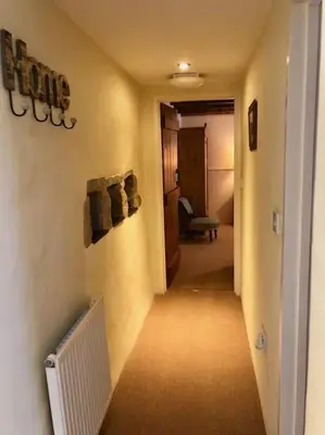 a hallway of a room with a heater on the wall at The Cider Barn in St Austell