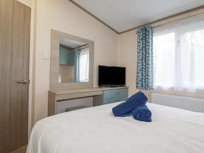 a bedroom with a bed with a television and a mirror at The Mermaid A04 in Par