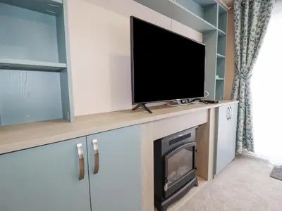 a flat screen tv sitting on top of a fireplace at The Mermaid A04 in Par