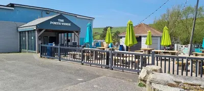 a fence with umbrellas in front of a restaurant at Coastal Retreat Newquay NB91 in Newquay
