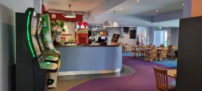 a restaurant with a bar and a dining area with tables at Coastal Retreat Newquay NB91 in Newquay