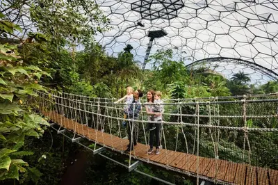three girls on a suspension bridge in an amusement park at Two Bedroomed Holiday Cottage with Sea Views in St Austell