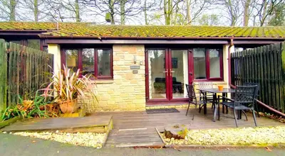 a house with a wooden deck with a table at Woodland View - Families & Pets in Uny Lelant