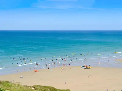 a group of people on a beach near the ocean at Beach House in Perranporth