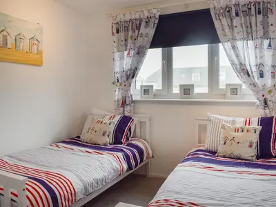 a bedroom with two beds and a window at Beach House in Perranporth