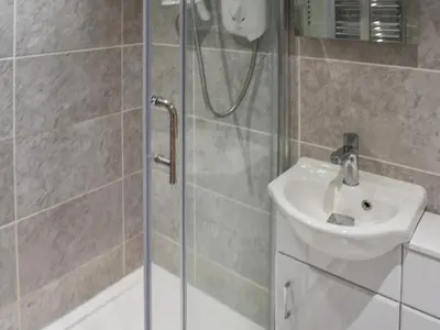 a bathroom with a shower and a sink at Beach House in Perranporth
