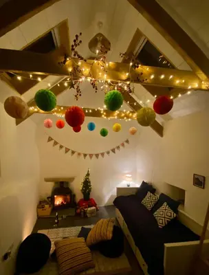 a living room with christmas lights and a couch at Cosy Barn A rural location near Tintagel in Tintagel