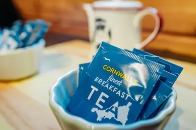 a bowl of tea bags on a table with a cup at Finlodge- Pet-Friendly Scandinavian Cabin in Callington