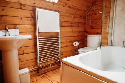 a bathroom with a toilet and a sink and a tub at Finlodge- Pet-Friendly Scandinavian Cabin in Callington