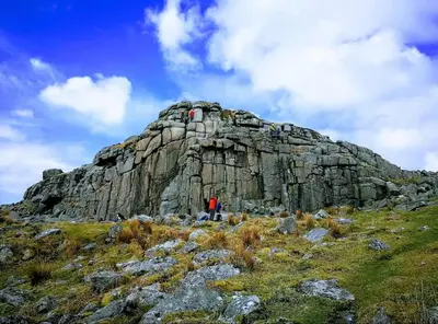 a person standing on top of a rocky mountain at Woodpecker Lodge- A Pet Friendly Rural Retreat in Callington
