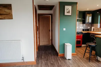 a kitchen with a blue and green wall at Woodpecker Lodge- A Pet Friendly Rural Retreat in Callington