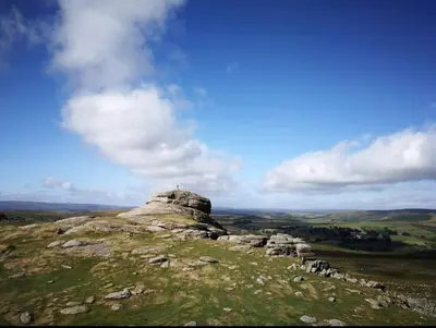 a person sitting on top of a mountain at Woodpecker Lodge- A Pet Friendly Rural Retreat in Callington