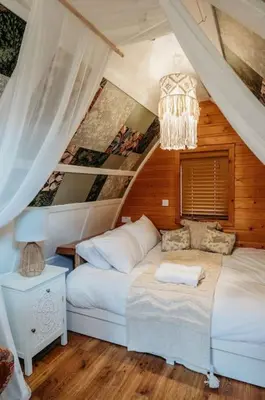 a bedroom with two beds and a chandelier at Robin Nest - Cosy Shepherd's Hut Hideaway in Callington