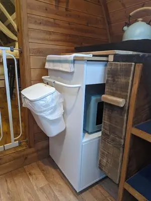 a small kitchen with a stove and a microwave at Robin Nest - Cosy Shepherd's Hut Hideaway in Callington