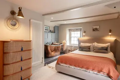 a bedroom with a bed and a bathroom with a tub at The Shambles in Port Isaac