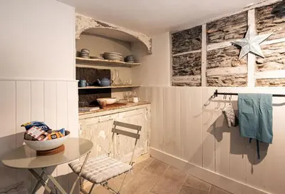 a kitchen with a table and a table and a counter at The Shambles in Port Isaac