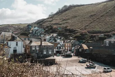 a village with cars parked in a parking lot at The Shambles in Port Isaac
