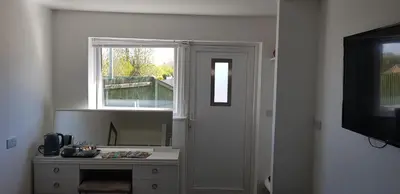 a room with a window and a table with a mirror at Self contained annex in Bodmin