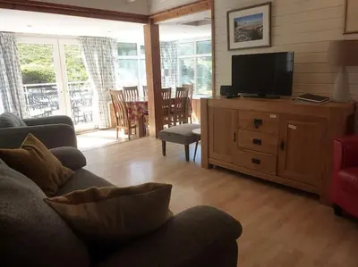 a living room with a couch and a flat screen tv at Tides Reach - Trebarwith Strand - North Cornwall - Sleeps 4 - 6 in Treknow