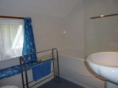 a bathroom with a tub and a sink and a toilet at Tides Reach - Trebarwith Strand - North Cornwall - Sleeps 4 - 6 in Treknow