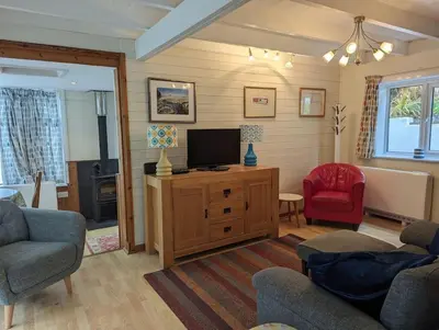 a living room with a tv on a wooden cabinet at Tides Reach - Trebarwith Strand - North Cornwall - Sleeps 4 - 6 in Treknow
