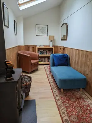 a living room with a blue chair and a tv at Tides Reach - Trebarwith Strand - North Cornwall - Sleeps 4 - 6 in Treknow