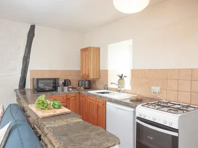 a kitchen with a sink and a stove top oven at Linhay in Looe