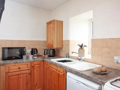 a kitchen with a sink and a microwave at Linhay in Looe