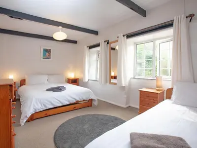 a bedroom with two beds and two windows at Linhay in Looe