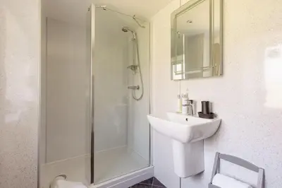 a white bathroom with a sink and a shower at Chypons Farm Bed & Breakfast in Penzance