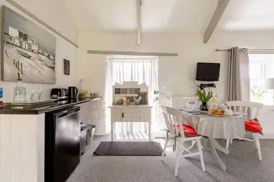 a kitchen with a table and a dining room at Chypons Farm Bed & Breakfast in Penzance
