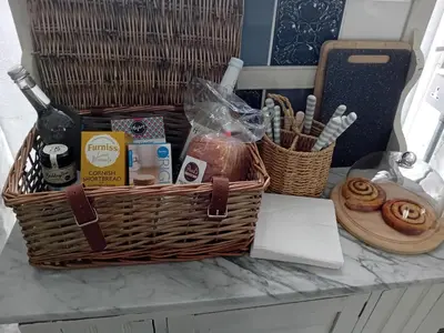 a basket on a counter with snacks and a bottle of wine at Chypons Farm Bed & Breakfast in Penzance