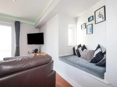 a living room with a couch and a flat screen tv at Apartment 2 in Newquay