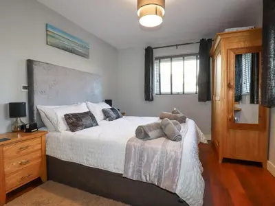 a bedroom with a bed with a teddy bear on it at Apartment 2 in Newquay