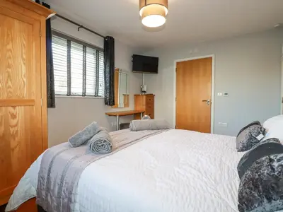 a bedroom with a large white bed and a window at Apartment 2 in Newquay