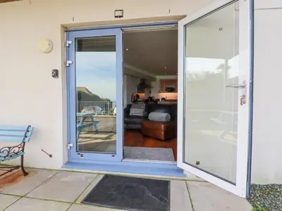 a sliding glass door with a view of a living room at Apartment 2 in Newquay