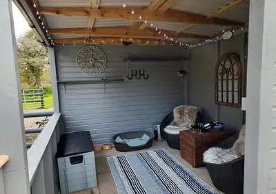 a garage with a clock on the wall and a chair at Beautiful Cabin near Padstow in Padstow