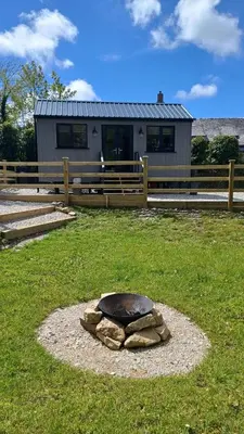 a stone sculpture in the grass in front of a house at Beautiful Cabin near Padstow in Padstow