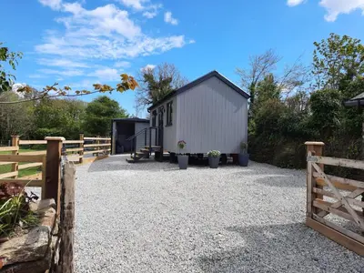 a barn conversion with a gravel driveway and a fence at Beautiful Cabin near Padstow in Padstow