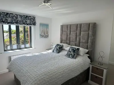 a bedroom with a large bed and two windows at Polmear Apartments, Charlestown in Charlestown