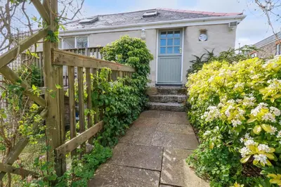 a house with a wooden fence and flowers at Moonlight in Truro