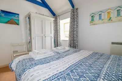 a bedroom with a bed with two towels on it at Moonlight in Truro