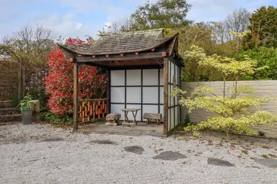 a small shed with a table in a garden at Moonlight in Truro