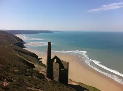 a view of the beach and ocean from a hill at Moonlight in Truro