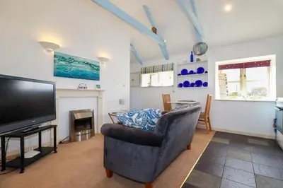 a living room with a chair and a television at Moonlight in Truro