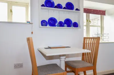 a kitchen with a table and blue plates on a wall at Moonlight in Truro