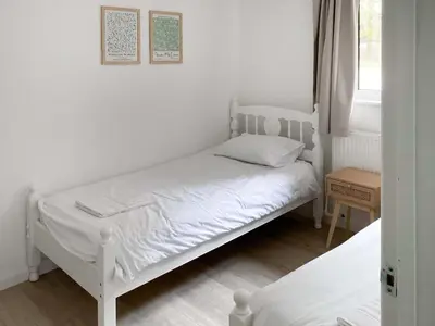 a bedroom with two beds and a window at Halcyons Rest in Saint Tudy
