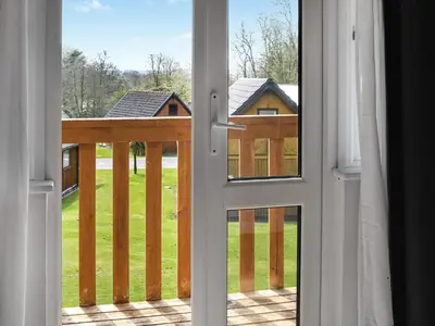 an open door with a view of a deck at Halcyons Rest in Saint Tudy